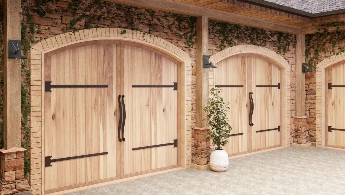 Portones de madera iluminados con apliques en un acceso al anochecer